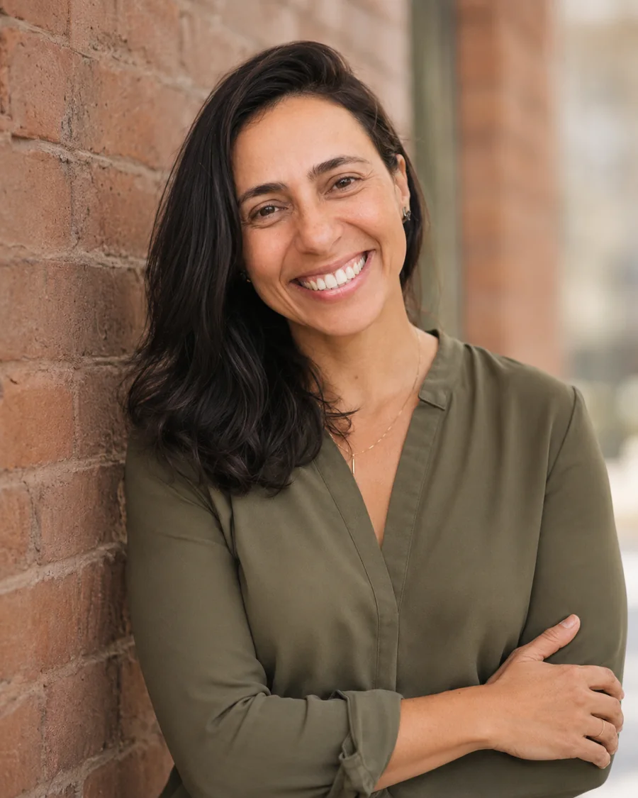 Fabi smiling by a brick wall