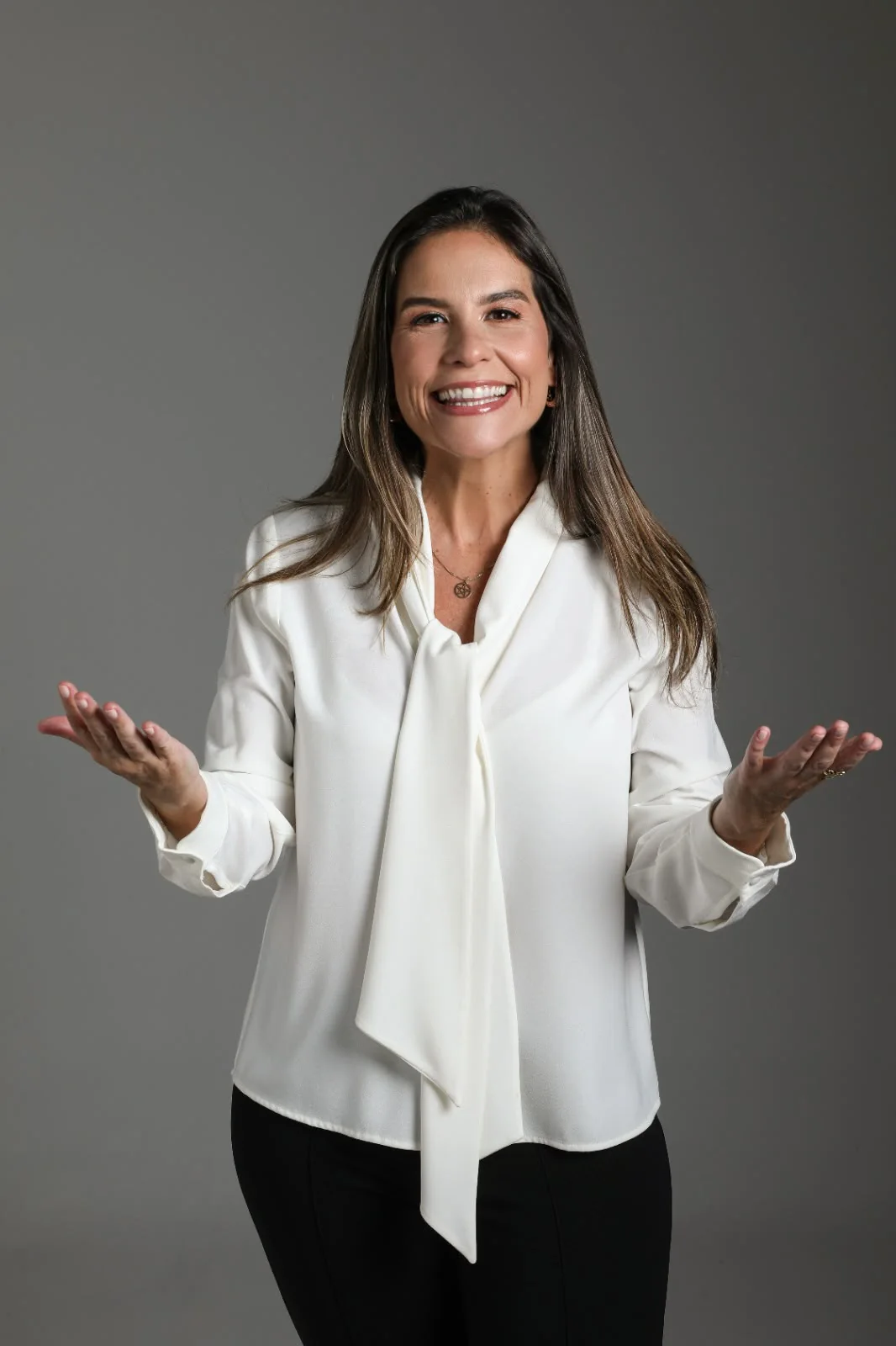 Lysia Henriques sorrindo, com as mãos abertas