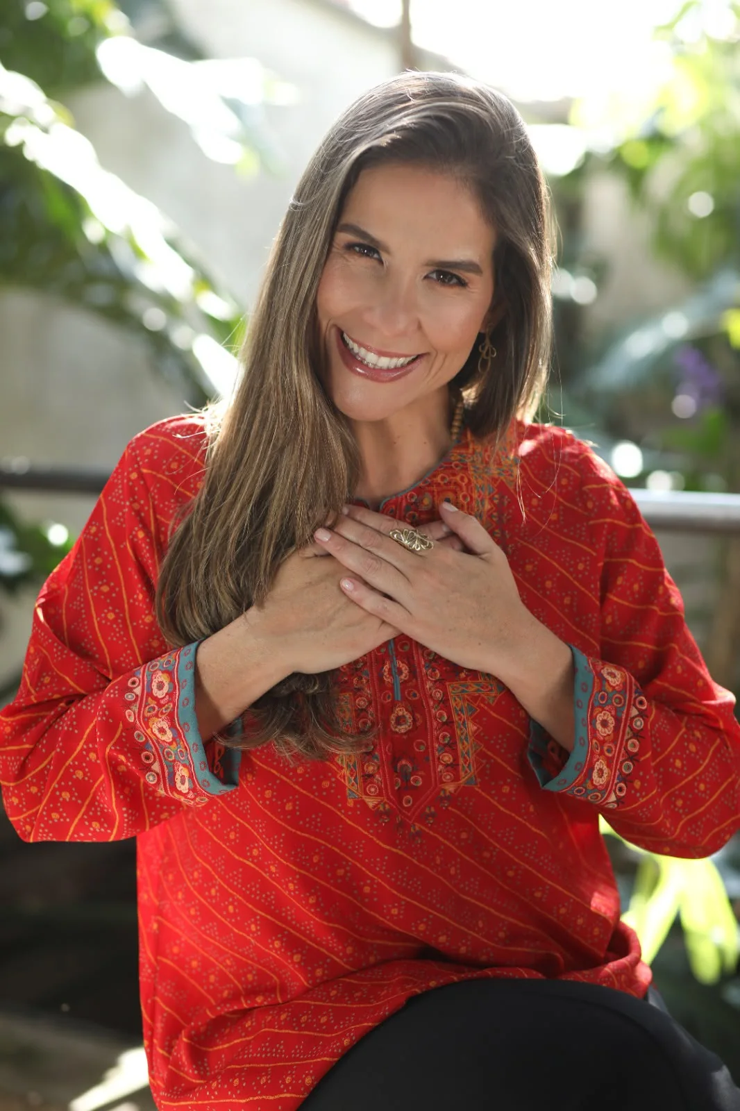Lysia Henriques sorrindo, com as mãos sobre o coração