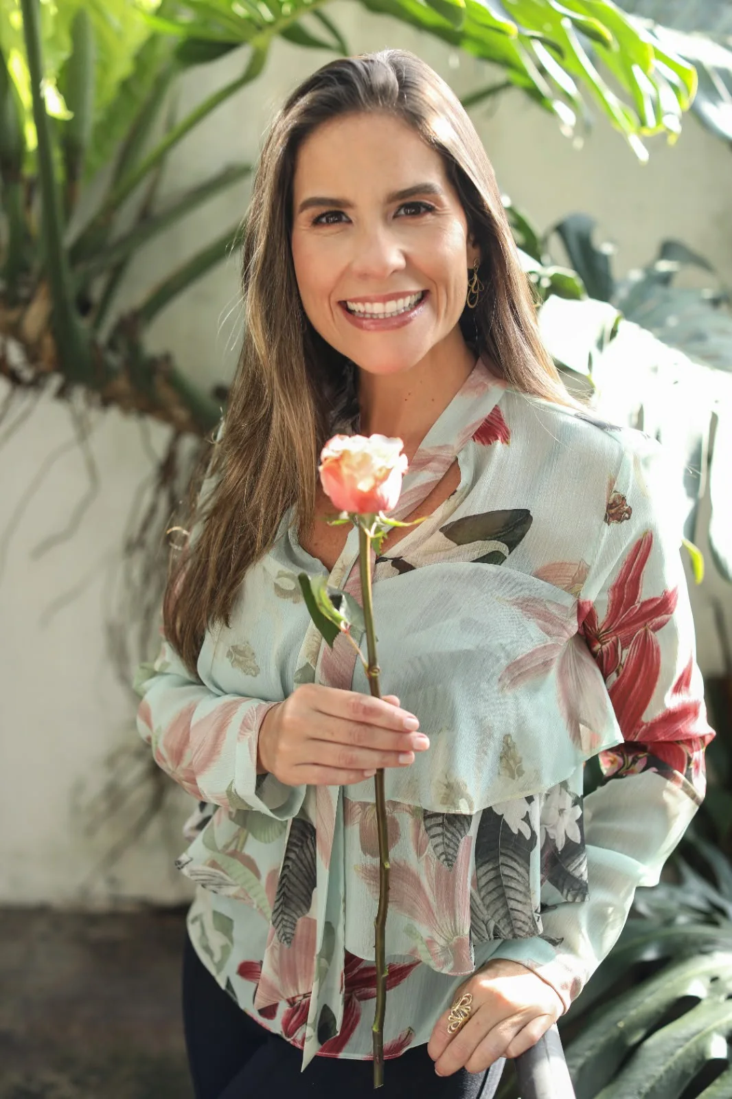 Retrato de Lysia Henriques em um ambiente com plantas